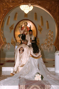 Orthodox wedding ceremony, the couple crowned before a gilded icon screen