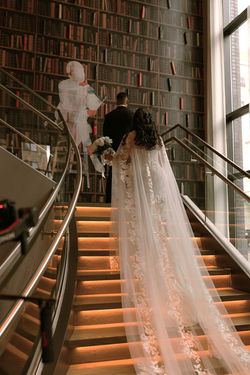 Bride descending a staircase with her veil cascading behind her